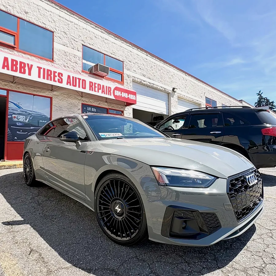 Silver Audi coupe on gloss black wheels outside Abby Tires