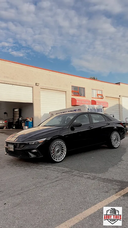 Black sedan on chrome wheels in the workshop bay