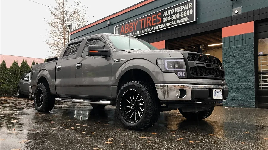 Grey Ford F-150 on black milled wheels outside the shop