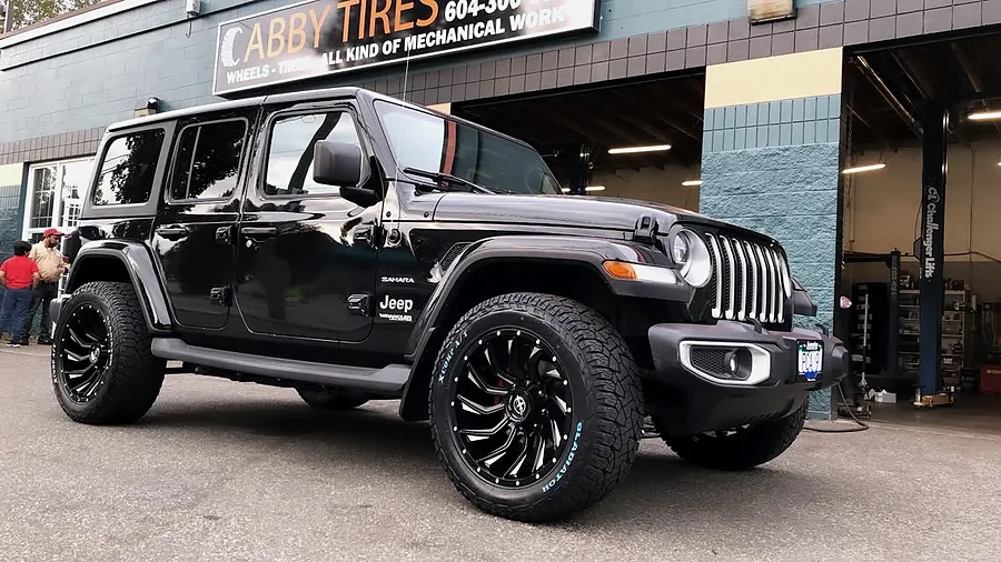Black Jeep Wrangler on machined off-road wheels outside the shop
